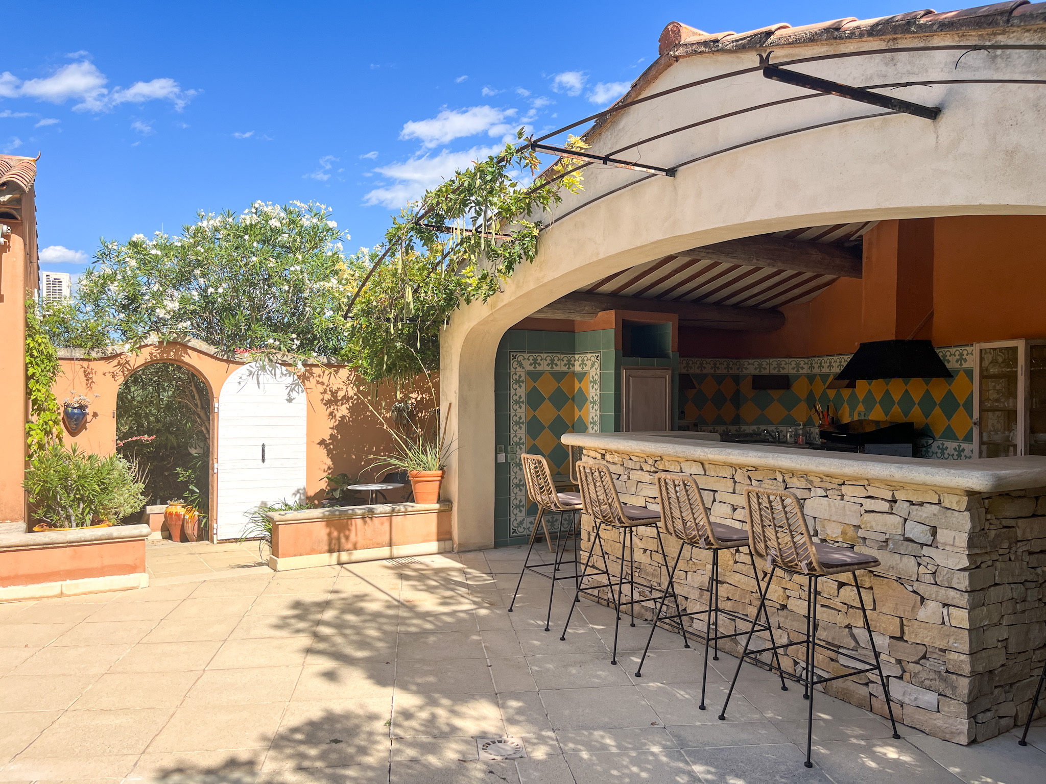 Espace détente extérieur avec cuisine d'été et plancha pour des déjeuners au bord de l'eau.