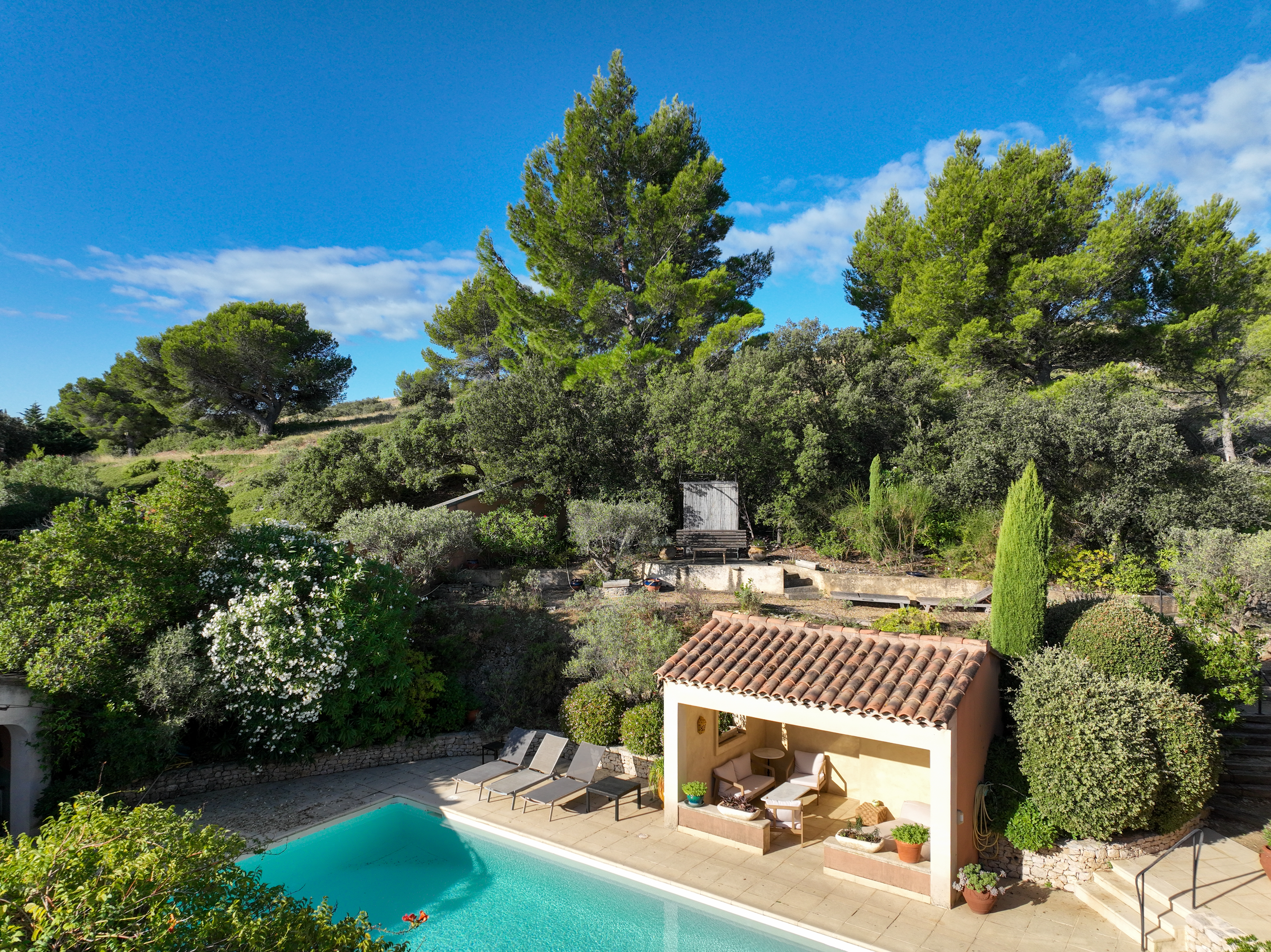 Vue sur le salon extérieur et la piscine de la Villa Olivia